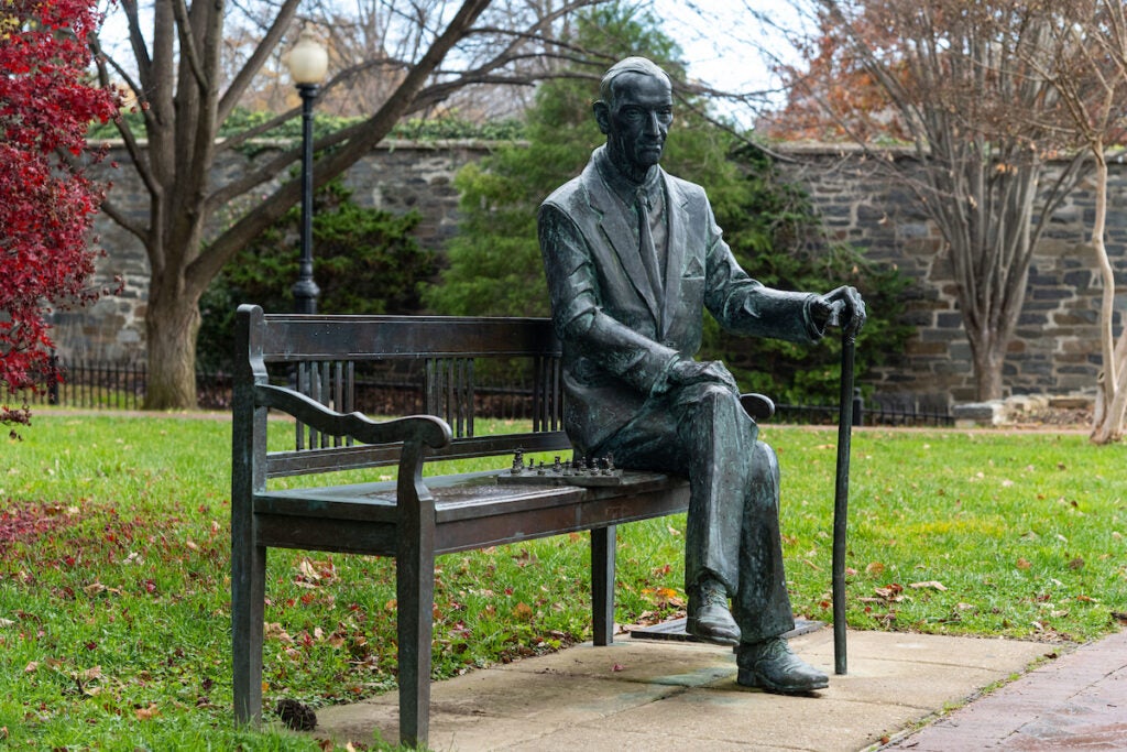 Karsksi statue sitting on a bench at Georgetown University from the Potomac River